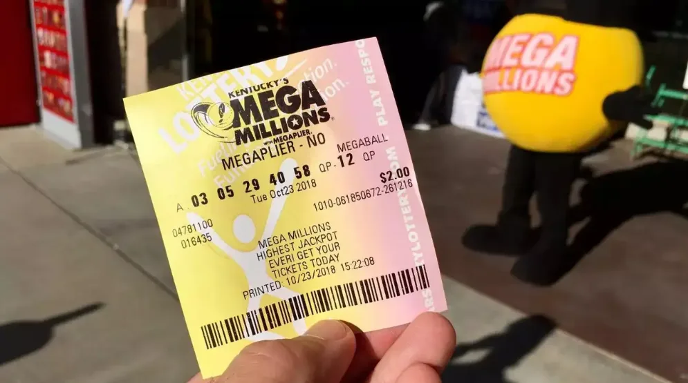 A hand holds a Kentucky Mega Millions lottery ticket with numbers 03, 05, 29, 40, 58 and Megaball 12, printed on October 23…