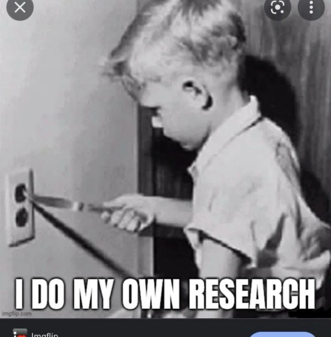 A black-and-white photo shows a young boy in profile, holding a knife and inserting it into an electrical outlet on a wall…