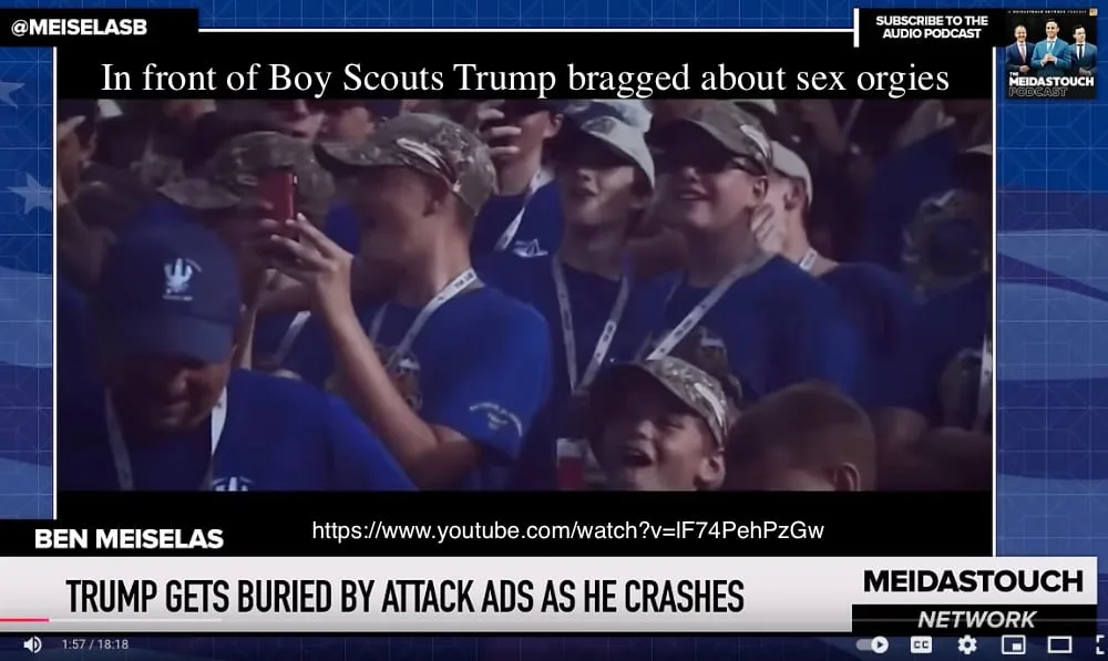 A screenshot from a news broadcast shows a crowd of young boys in blue shirts and camouflage hats, some smiling and holding…