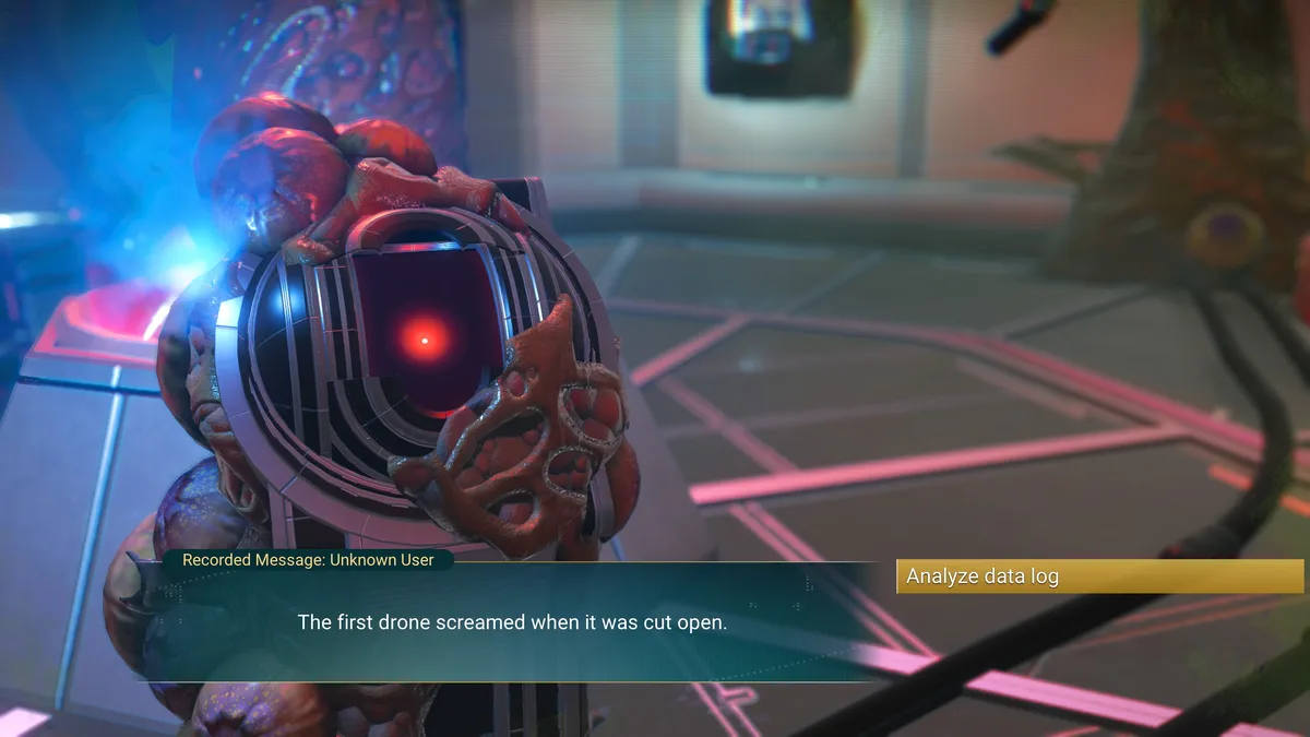 A screenshot from a sci-fi game shows a grotesque, organic drone with a glowing red eye and fleshy, pulsating appendages. A…