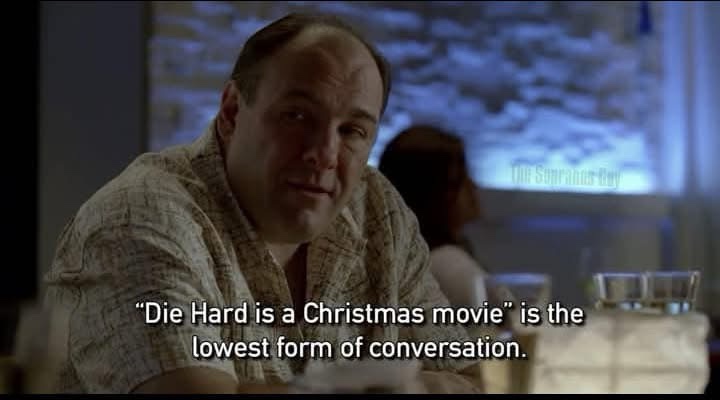 A man with a receding hairline and a serious expression sits at a table in a dimly lit restaurant. The overlaid text reads…