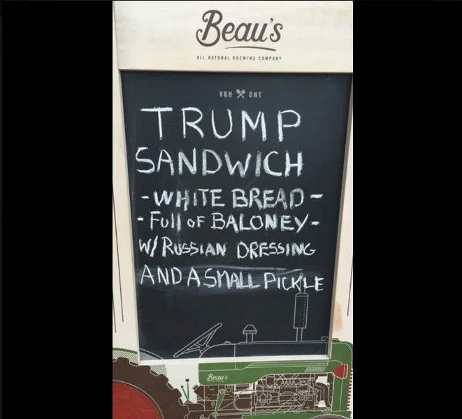 A chalkboard menu from Beau's All Natural Brewing Company lists a 'Trump Sandwich' with ingredients including 'white bread,'…