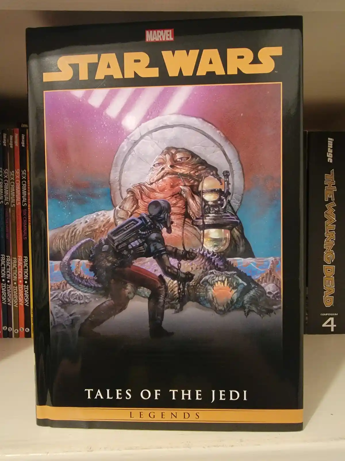 A Marvel Star Wars Legends hardcover comic book titled 'Tales of the Jedi' sits on a shelf, its cover featuring a large…