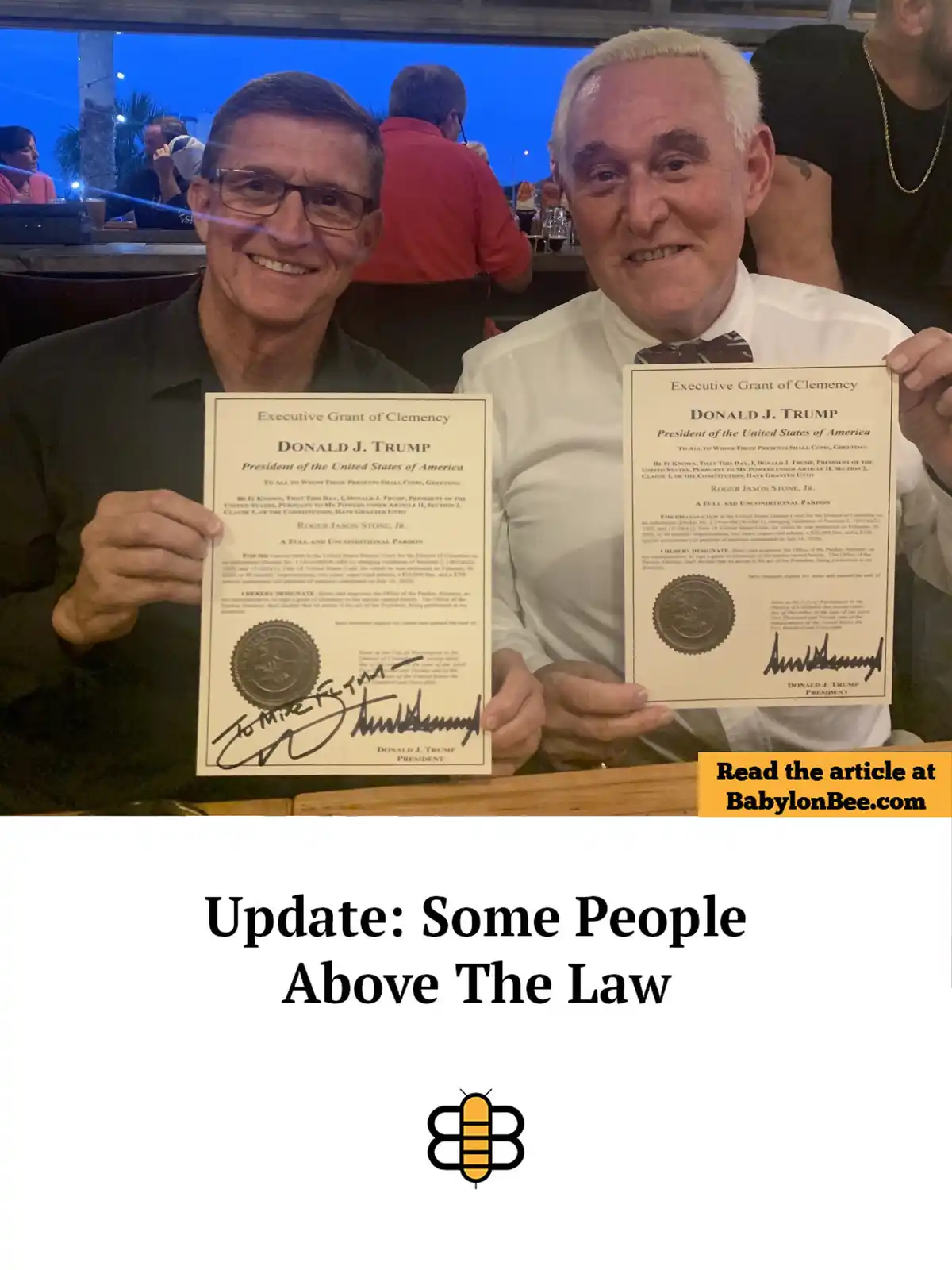 Two men are seated at a bar, each holding up a fake 'Executive Grant of Clemency' document signed by Donald J. Trump…