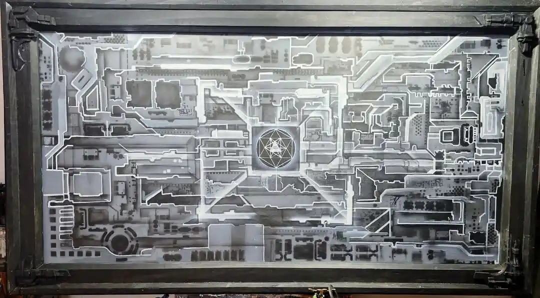 A grayscale, intricate architectural blueprint or map of a complex building or city layout, framed in dark wood, with a…