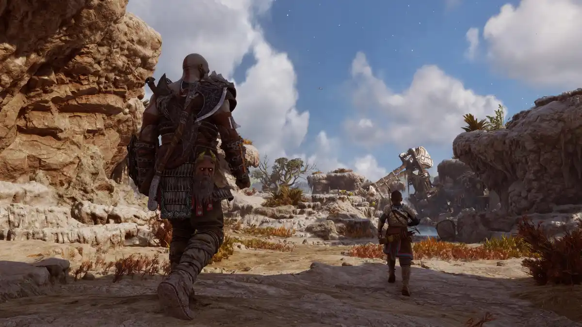 In a rocky, desert-like landscape from the video game God of War, the protagonist Kratos walks away from the camera with his…