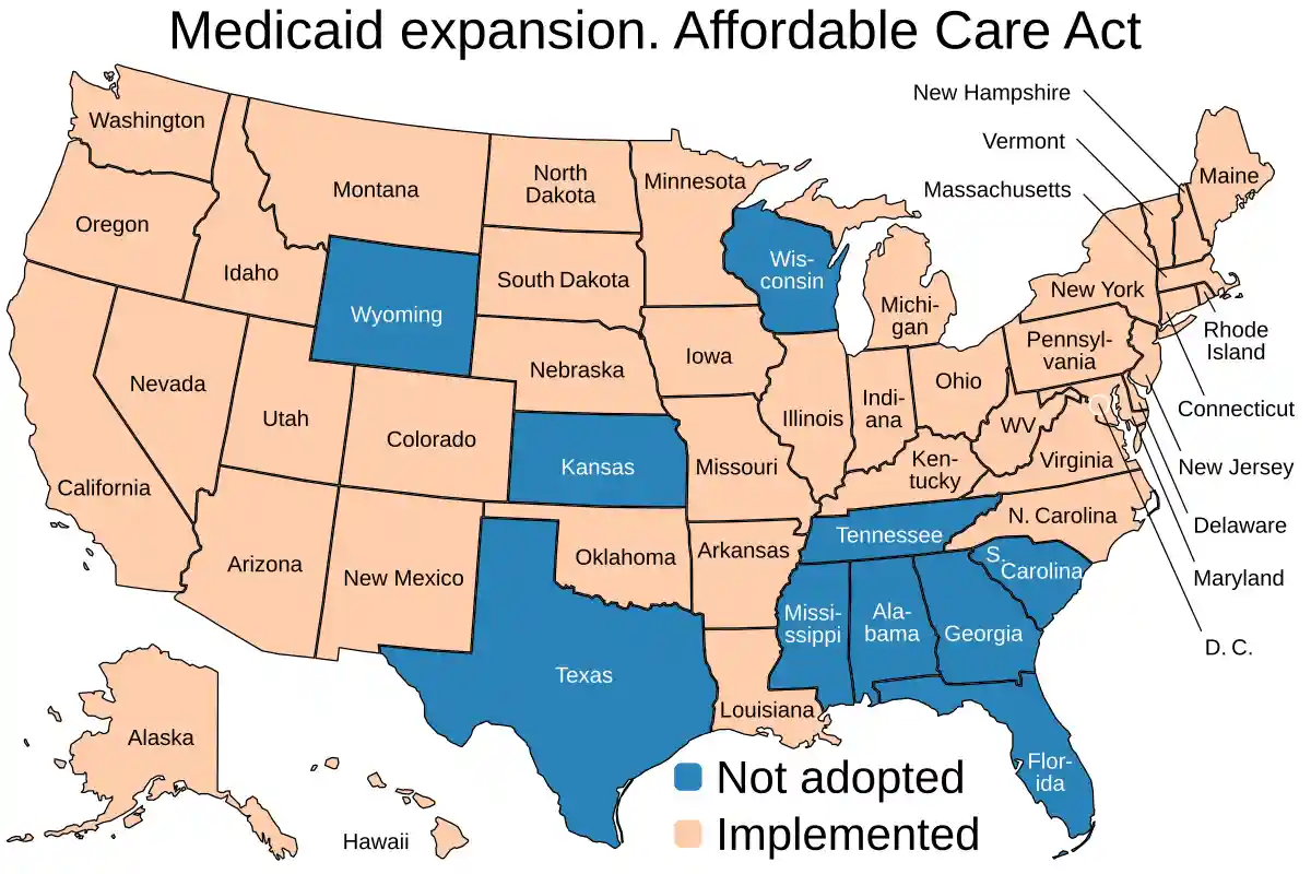 A map of the United States showing states colored in peach (implemented) or blue (not adopted) for Medicaid expansion under…