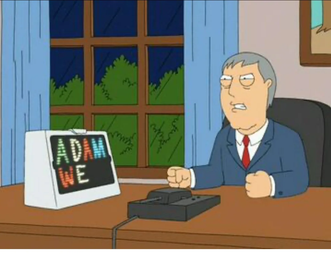 A cartoon man in a suit sits at a desk with a vintage computer displaying the text 'ADAM WE'. He has a frustrated expression…