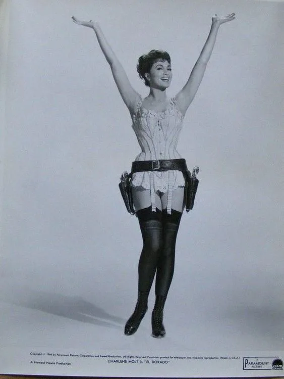 A black-and-white promotional photo of actress Charlene Holt in the 1948 film 'El Dorado', wearing a corset, garter belt…