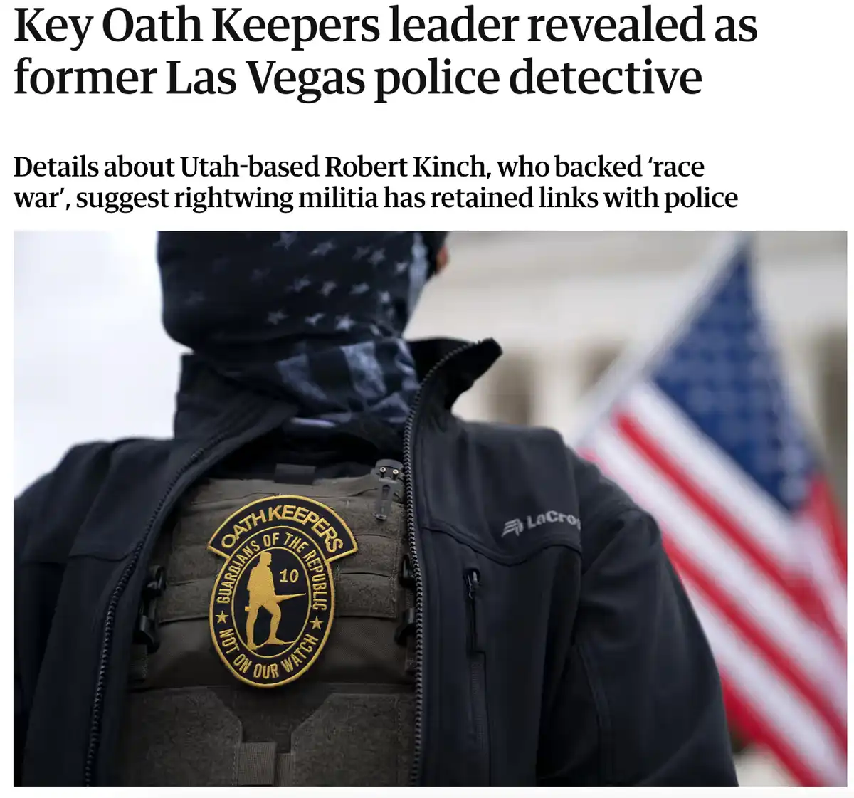 A person wearing a black jacket and tactical vest with an 'Oath Keepers Guardians of the Republic' patch is shown from…