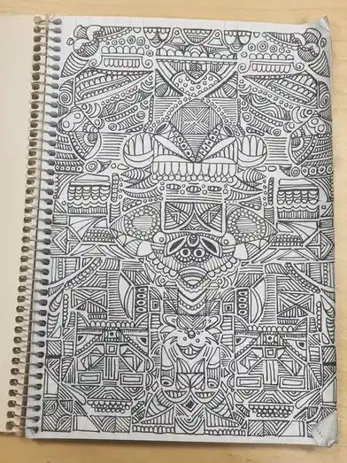 A black-and-white, intricate doodle fills a spiral-bound notebook page, featuring a dense, symmetrical pattern of geometric…