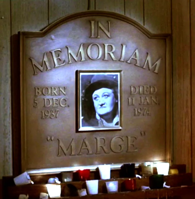 A bronze memorial plaque with the engraved text 'IN MEMORIAM', birth and death dates (born 5 Dec. 1937, died 11 Jan. 1974)…