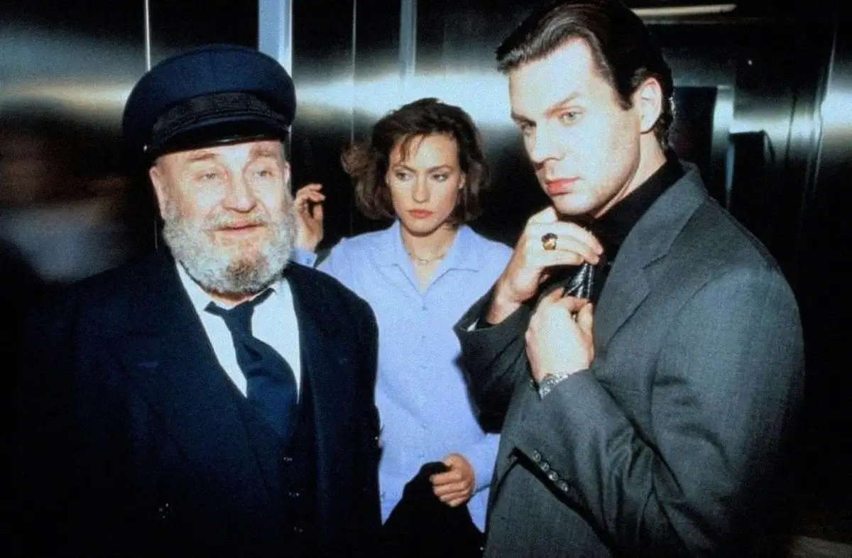 A still from the movie 'The Untouchables' shows three characters in an elevator: a bearded man in a captain's hat and suit…