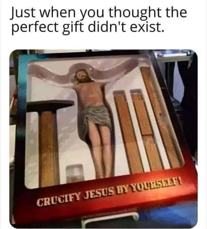 A product box contains a figurine of Jesus on a cross, with wooden stakes and a small hammer beside him. The box's red label…