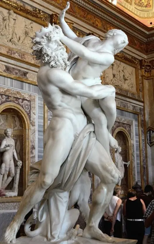 a marble sculpture depicting a muscular man with a beard and crown grappling with a woman, set against an ornate, gilded…