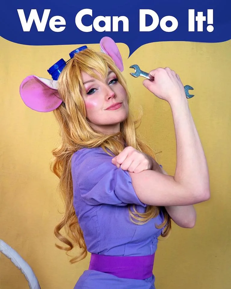 A woman with blonde hair and pink mouse ears, wearing a purple outfit and holding a wrench, poses with her arm flexed in a…