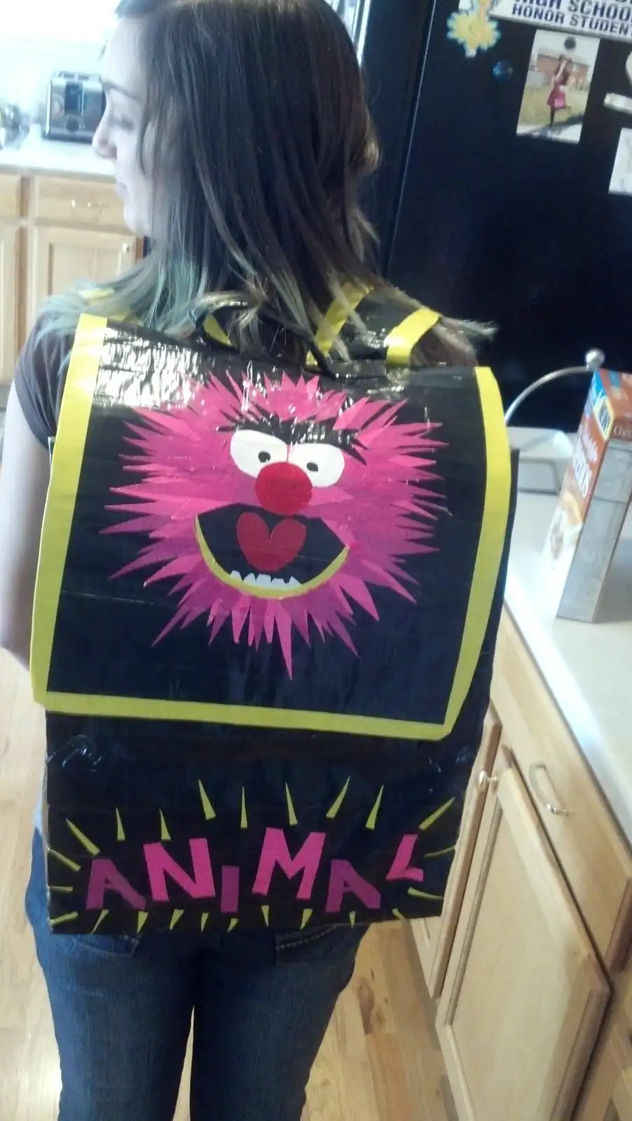 A person is seen from behind wearing a homemade costume made of duct tape, featuring a large pink Muppet character with…