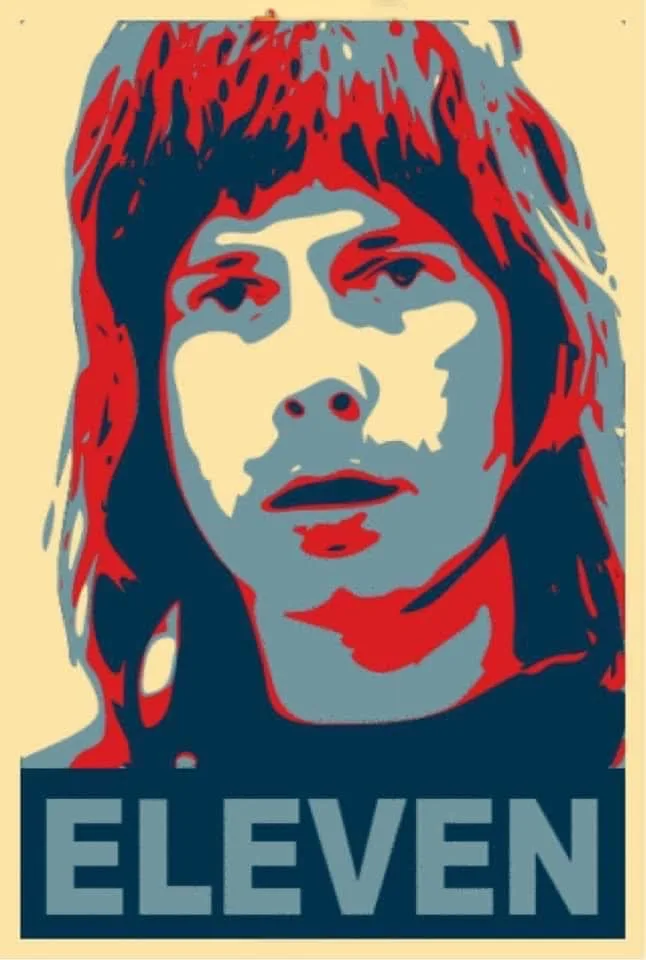 A stylized, posterized portrait of a person with long hair, rendered in red, blue, and cream tones, with the word 'ELEVEN'…