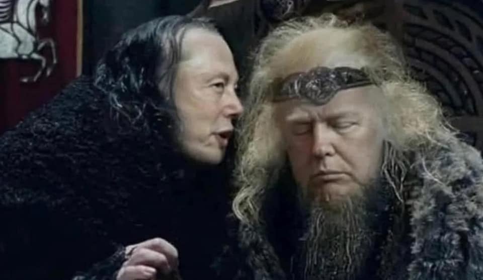 a man with dark hair and a black fur coat leans in to whisper to another man with long blonde hair, a beard, and a headband…