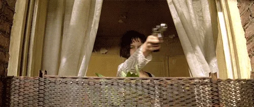 A woman with short dark hair, wearing a white lace top, is shown in six panels firing a handgun from behind a wicker balcony…
