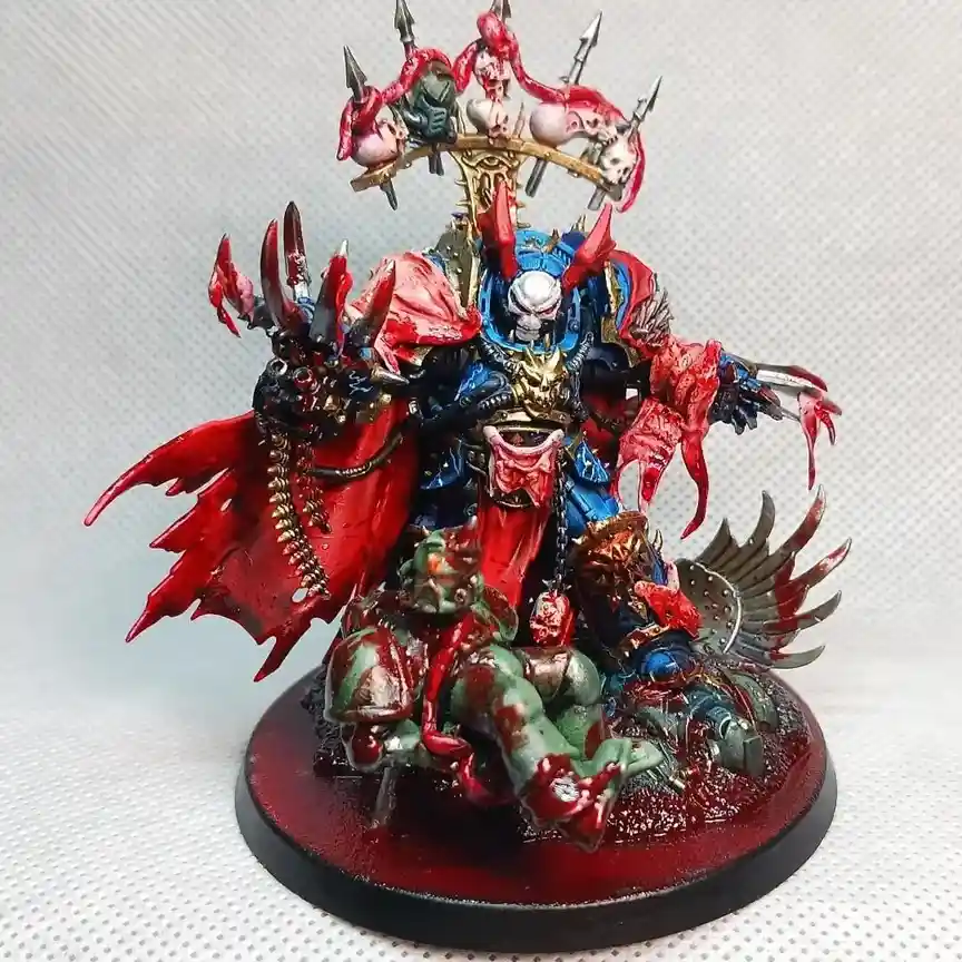 A highly detailed, blood-splattered miniature of a fantasy warlord with red wings, skulls, and spikes, standing over a…
