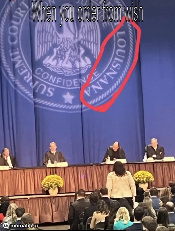 A photo of a courtroom with four judges seated at a bench, facing an audience. Behind them is a large blue curtain featuring…