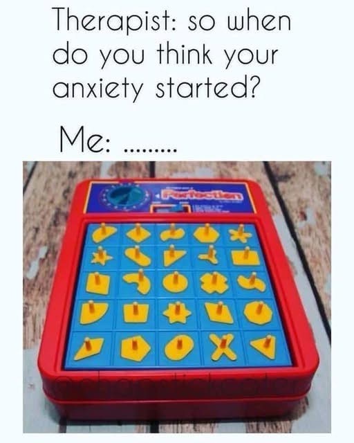 An image of a red and blue 'Perfection' puzzle game with yellow plastic pieces arranged in a grid on a wooden surface. The…