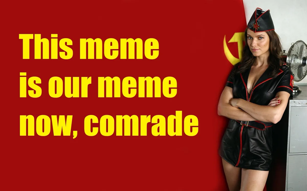A woman in a black leather Soviet-style uniform with red trim and a matching hat stands with arms crossed against a red…