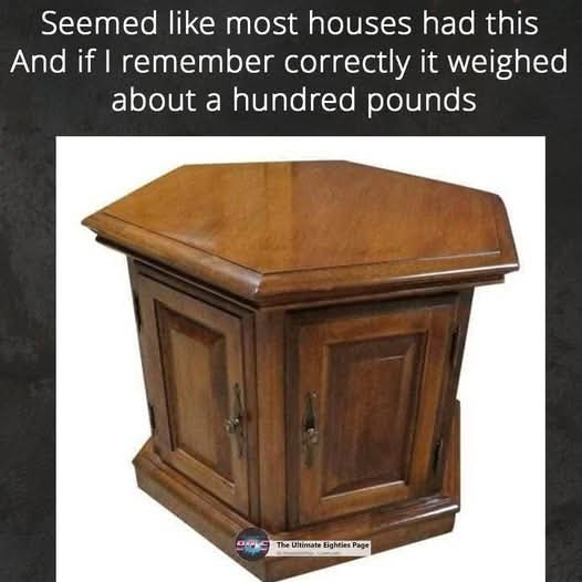 A photo of a hexagonal wooden cabinet with two doors and ornate metal handles, set against a white background. The overlaid…