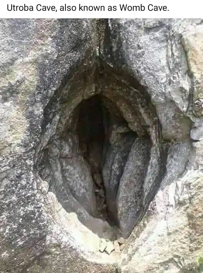 The image shows a natural rock formation shaped like a human vagina, with the text 'Utroba Cave, also known as Womb Cave.'…