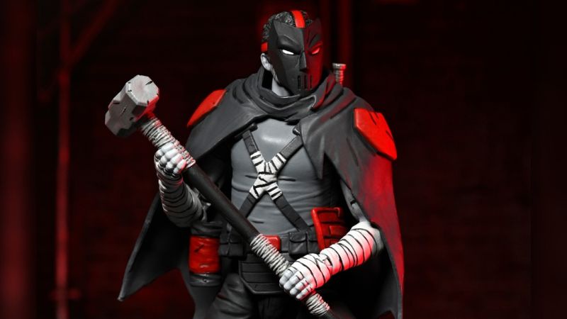 A statue of the comic book character Deathstroke, wearing his signature black and red armor and mask, holding a large…