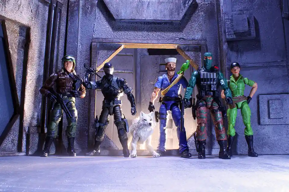Five G.I. Joe action figures and a white wolf figurine are posed in front of a stylized doorway. From left to right: a…