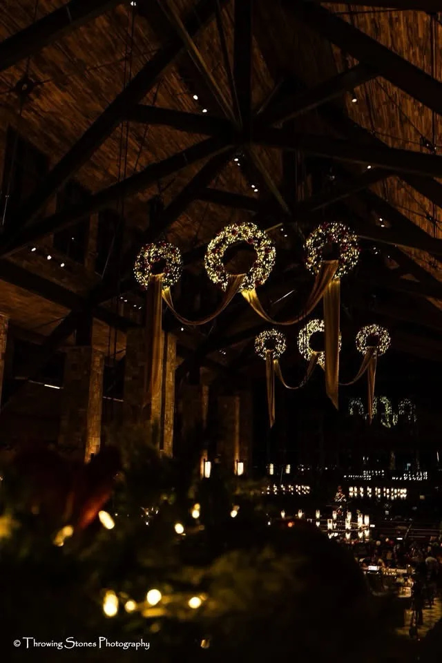A dimly lit, festive indoor space with wooden beams and hanging wreath chandeliers, overlaid with the text 'i'm not a fan of…