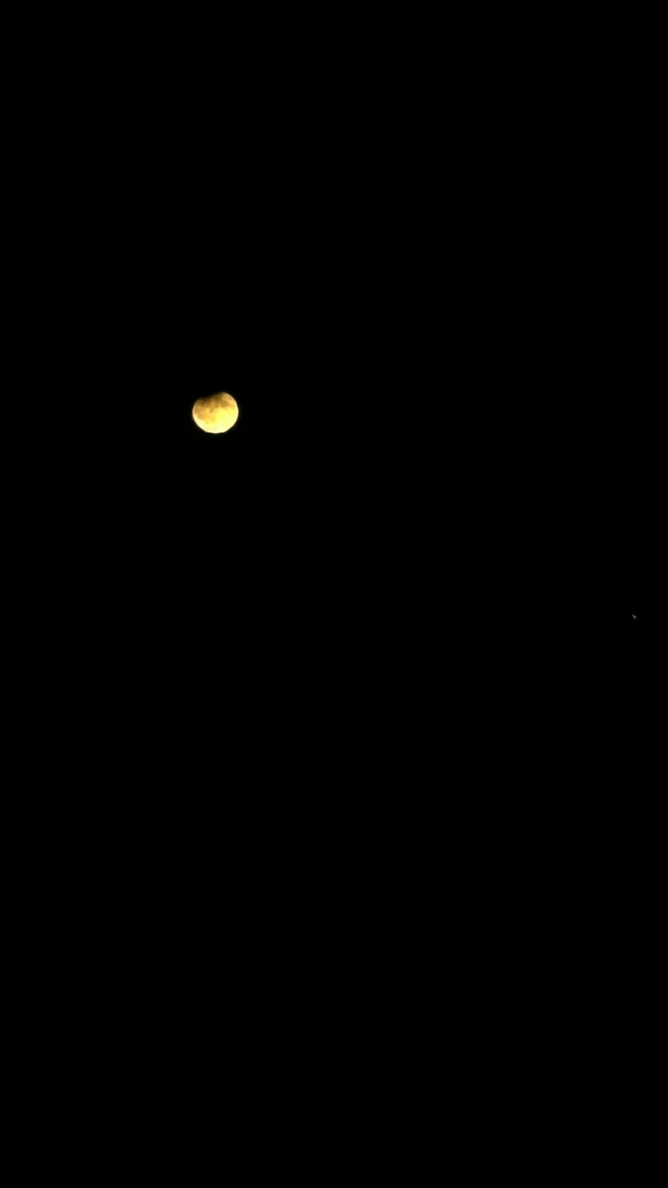 A dimly lit, yellowish moon is visible against a completely black night sky. The image is overlaid with the text 'i'm not…