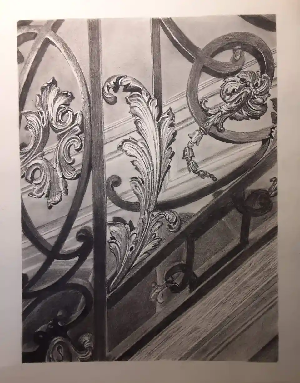 A detailed pencil sketch shows ornate, baroque-style metalwork on a staircase railing, featuring swirling acanthus leaves…