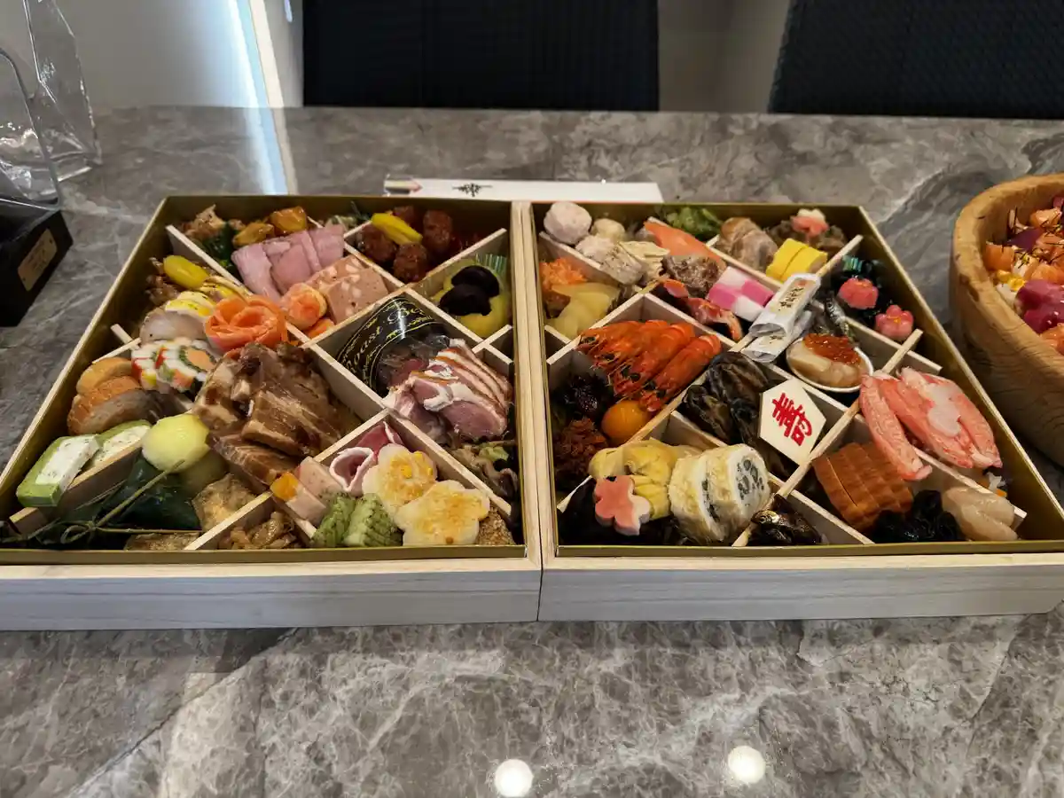 a lavish, compartmentalized wooden box filled with an assortment of colorful, meticulously arranged Japanese dishes…