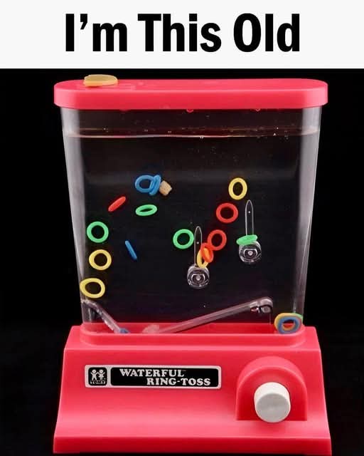 A red plastic 'Waterful Ring-Toss' game with colorful rings floating in water inside a clear container. The rings are…