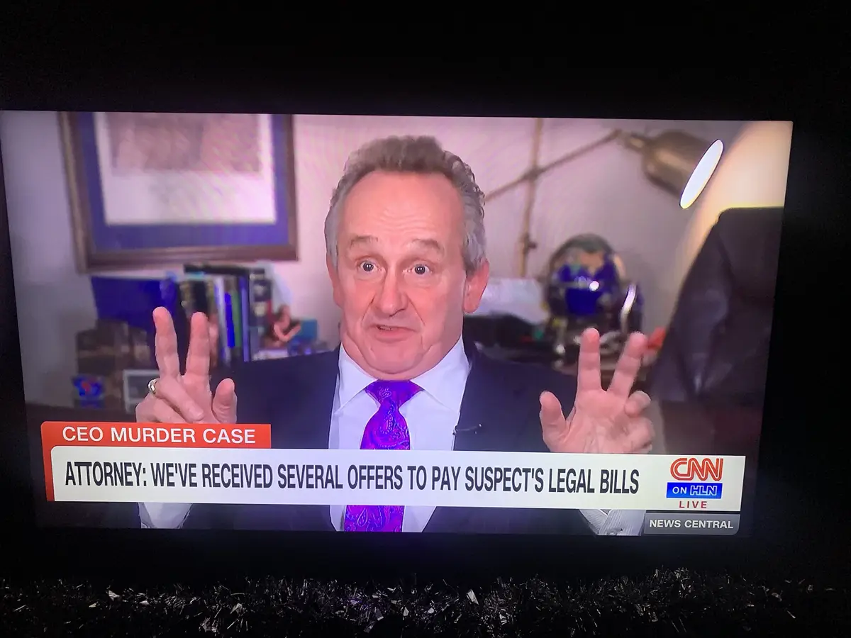 A man in a suit and purple tie is on a CNN news broadcast, gesturing with both hands while speaking. The lower third graphic…