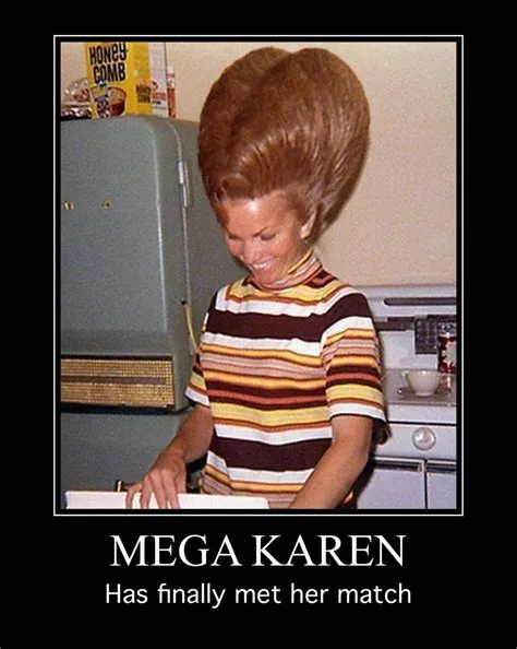 A woman with an extremely tall, bouffant hairstyle stands in a retro kitchen, smiling while preparing food. She wears a…