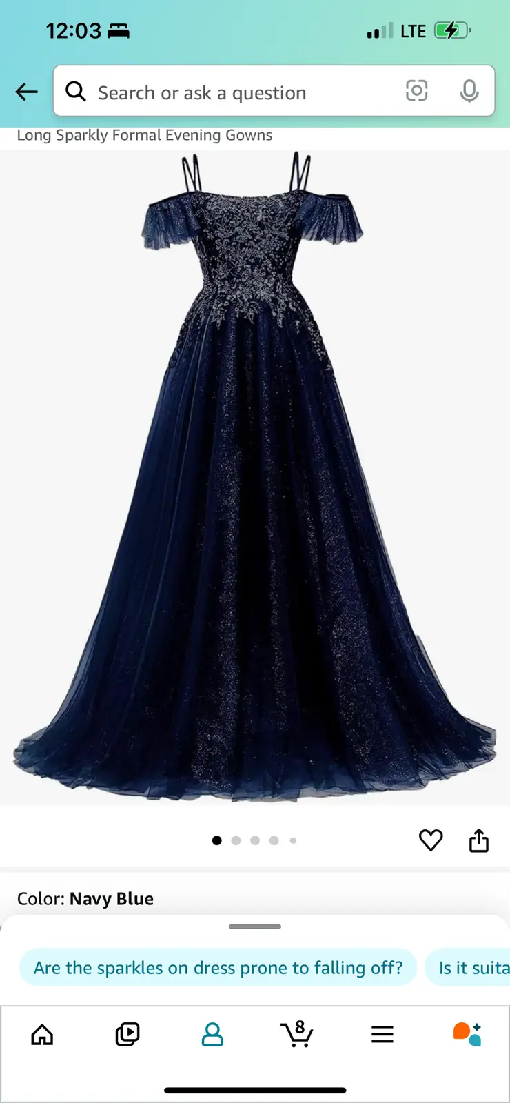 A screenshot of a mobile shopping app displaying a navy blue, sparkly, off-the-shoulder formal evening gown. The overlaid…
