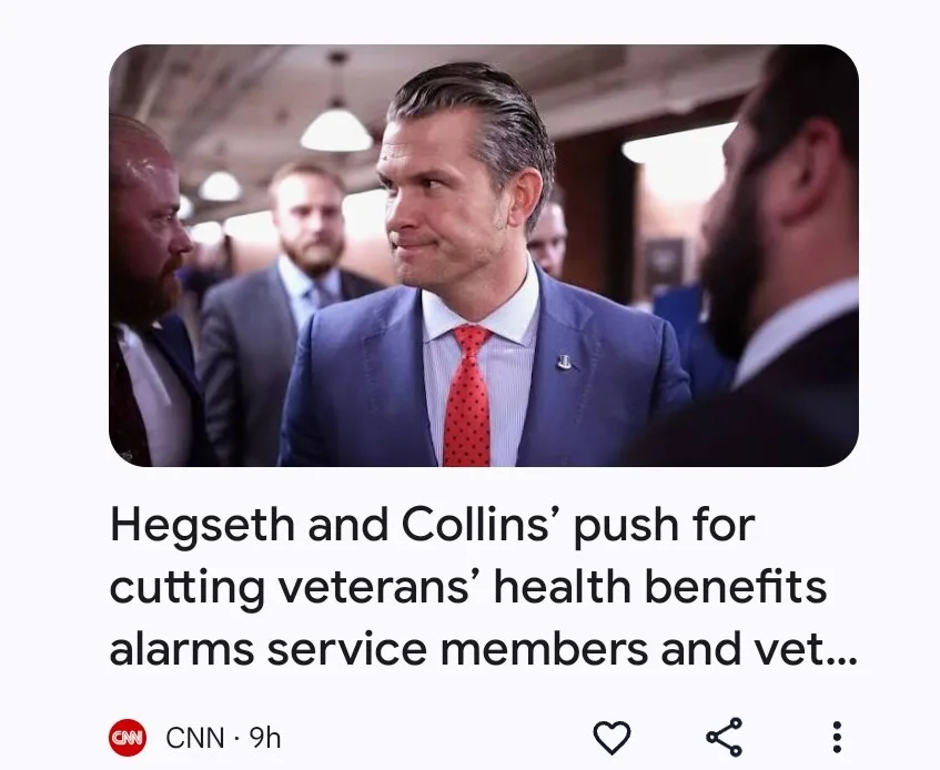 A man in a blue suit and red polka-dot tie looks sideways with a skeptical expression while surrounded by other men in…