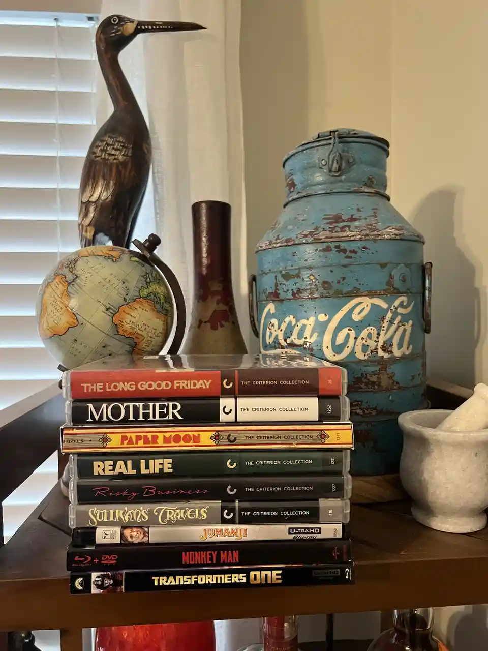 A stack of movie cases, including Criterion Collection titles like 'The Long Good Friday' and 'Mother', sits on a shelf next…