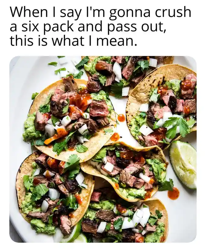 An overhead photo shows a white plate piled with six soft tacos, each loaded with guacamole, chopped onions, cilantro, and…