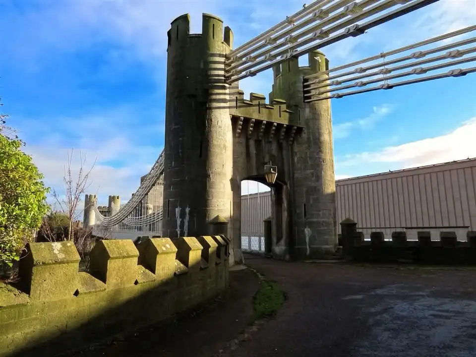 A photo of a bridge with castle-like stone towers and battlements under a blue sky, overlaid with the text 'i'm not a…