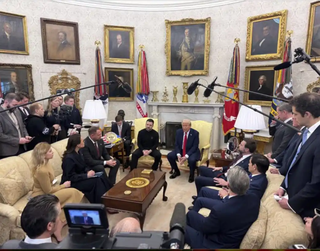 A formal meeting in the Oval Office features Donald Trump seated in a yellow chair, facing Ukrainian President Volodymyr…