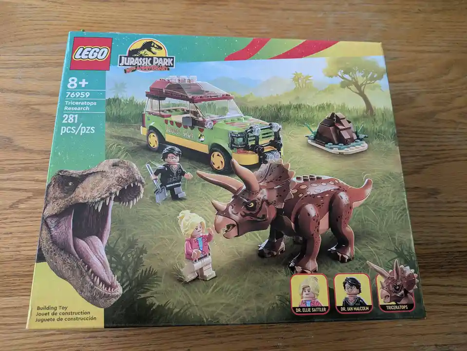 The image shows a LEGO Jurassic Park 30th Anniversary set box (76959) featuring a green research vehicle, a LEGO…