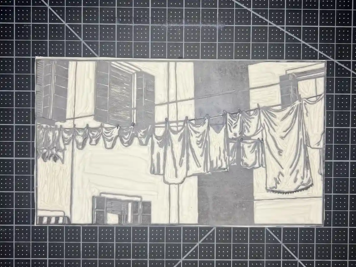 A grayscale, textured drawing depicts a row of buildings with windows and shutters, featuring laundry hanging on a line…