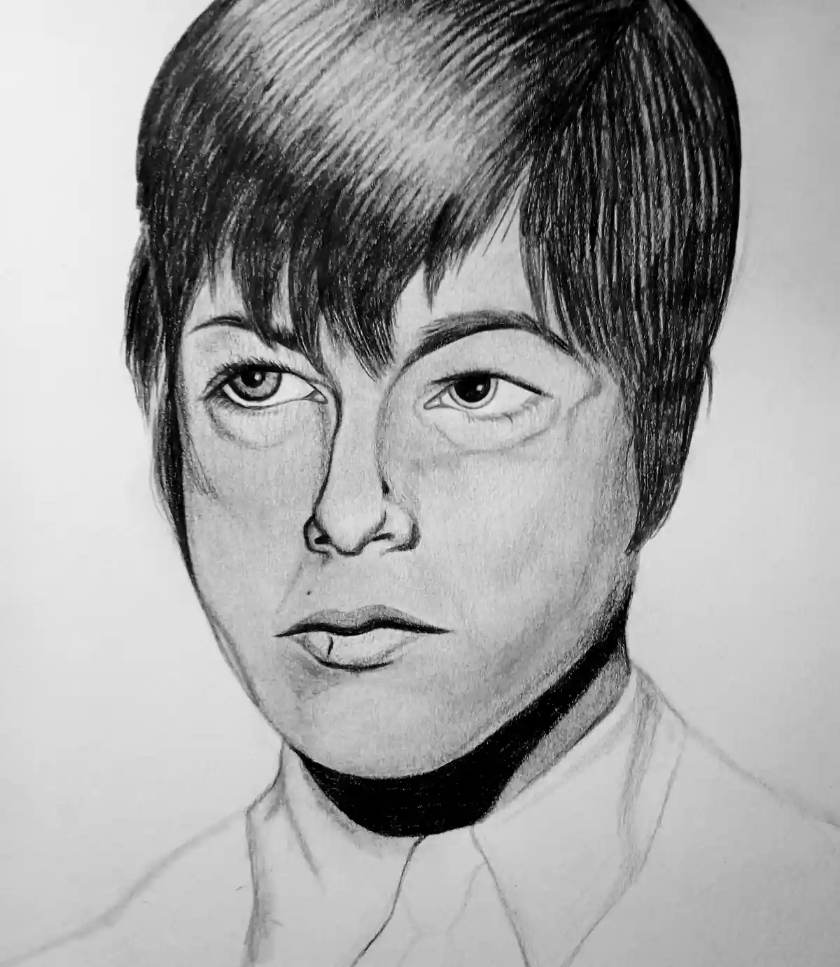 A detailed pencil sketch of a person with short dark hair, intense eyes, and a neutral expression, wearing a white collared…