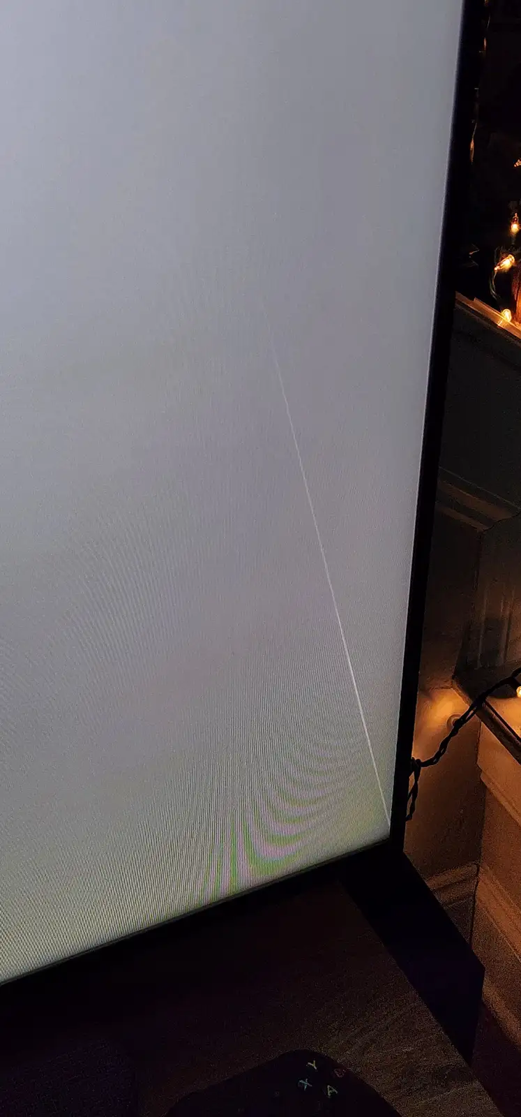 A close-up of a TV screen showing a bright, diagonal white line running from top to bottom, with distorted, wavy color bands…
