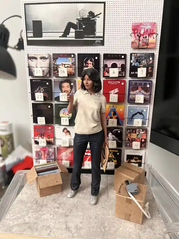A miniature figurine of a woman in a beige polo shirt and jeans stands in front of a pegboard wall displaying numerous…